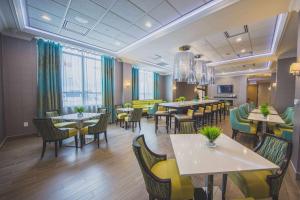 une salle à manger avec des tables et des chaises dans un restaurant dans l'établissement Hampton Inn & Suites by Hilton Bolton, à Bolton