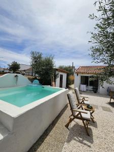 una gran piscina con 2 sillas y una casa en Além do Tejo, en Arraiolos
