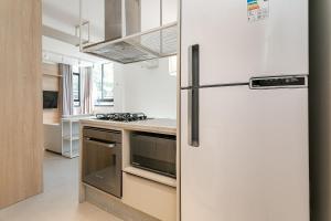 uma cozinha com um frigorífico e um fogão em Xtay Soho Florianópolis em Florianópolis