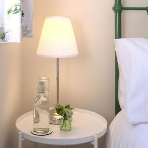 lampa na białym stole obok łóżka w obiekcie Meadowbrook House w mieście Halwell