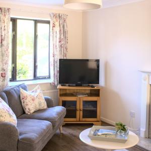 a living room with a couch and a flat screen tv at Meadowbrook House in Halwell