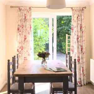 uma mesa de jantar com cadeiras e uma janela em Meadowbrook House em Halwell