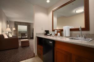 Baño del hotel con lavabo y espejo en Hampton Inn Sheridan en Sheridan