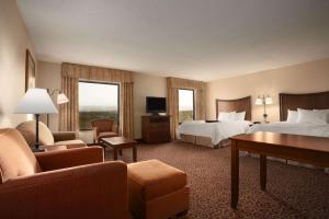 シェリダンにあるHampton Inn Sheridanのベッド2台とリビングルームが備わるホテルルームです。