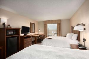 a hotel room with two beds and a television at Hampton Inn Sheridan in Sheridan