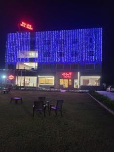 un bâtiment avec des lumières bleues allumées la nuit dans l'établissement Bellazio Suites Hotel & Resort, à Bareilly