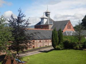 a large brick building with a tower on top of it at Old Whisky Distillery Apartment in Fort William