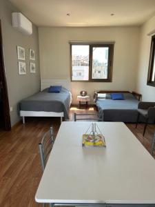a room with two beds and a table and chairs at Extremely comfy 10min walk to Beach & Town in Larnaka