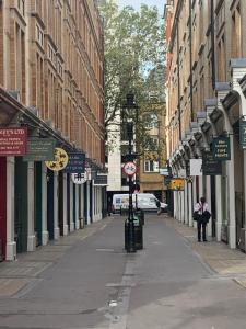 een lege straat met gebouwen en een persoon op de stoep bij St Martins in Londen
