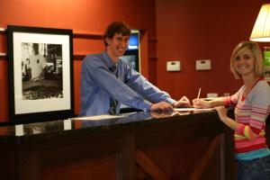 a man and a woman standing behind a counter at Hampton Inn & Suites Wilder in Wilder
