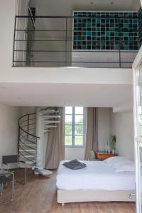 a bedroom with a loft bed and a spiral staircase at Domaine de la Bedosse in Alès