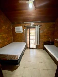 Cette chambre comprend 2 lits et une fenêtre. dans l'établissement Casa Paraíso, à Gravatá