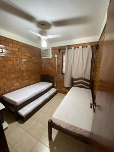 a bedroom with two beds and a brick wall at Casa Paraíso in Gravatá +17 photos