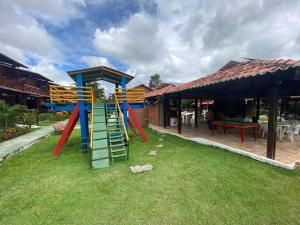 a playground with colorful slides in a yard at Casa Paraíso in Gravatá