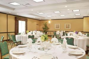 una sala de banquetes con mesas y sillas blancas en Hilton Garden Inn Warner Robins en Warner Robins