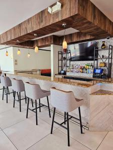 un bar avec une rangée de chaises dans un restaurant dans l'établissement Hilton Garden Inn Warner Robins, à Warner Robins