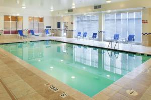 una piscina con sillas azules en un edificio en DoubleTree by Hilton Greensboro en Greensboro