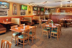 comedor con mesas y sillas de madera en DoubleTree by Hilton Greensboro en Greensboro