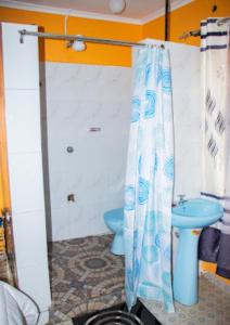 a bathroom with a blue toilet and a shower curtain at Secure Standalone 3BR Home near Embu Uni and KSG in Embu +19 photos