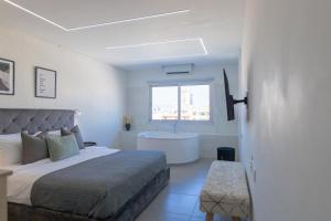 a bedroom with a bed and a bath tub at Phaedrus Living: Plateia Suite Verde in Nicosia