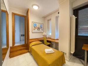 a bedroom with a bed and a desk and a window at Hotel Dei Fiori in Milan