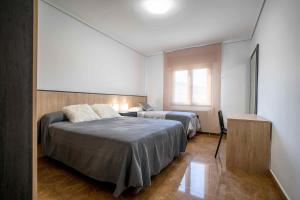 1 dormitorio con 2 camas y ventana en Casa Palau, en Morella