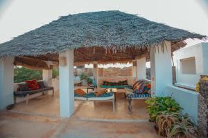 um pavilhão com sofás e um telhado de palha em Amu House em Lamu