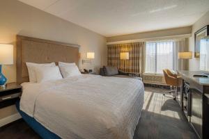 カールスタットにあるハンプトン イン カールスタッド アット ザ メドウランズのベッドとデスクが備わるホテルルームです。