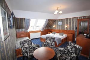 a bedroom with a bed and a table and chairs at Old Prague Hotel in Prague