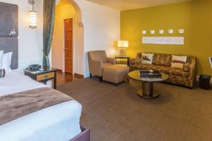 a hotel room with a bed and a couch at Hotel Andaluz Albuquerque, Curio Collection By Hilton in Albuquerque