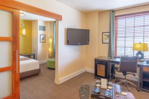 a hotel room with a bed and a desk and a television at Hotel Andaluz Albuquerque, Curio Collection By Hilton in Albuquerque