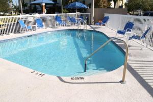 uma grande piscina com cadeiras e um guarda-sol em Hampton Inn Tampa-Rocky Point em Tampa