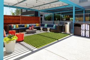 eine Terrasse mit Sofas, einem Tisch und Gras in der Unterkunft Tru by Hilton Round Rock in Round Rock