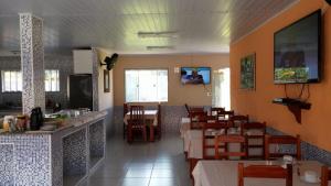 a dining room with tables and chairs in a restaurant at Forte Do Pouso Hospedagens in Saquarema