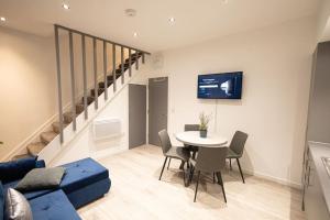 a living room with a blue couch and a table at Comfort on Market St l 1BR 1BA l Gem in Watford in Watford