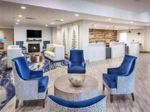 a lobby with blue chairs and a table and a fireplace at DoubleTree by Hilton Monroe Township Cranbury in Rossmoor