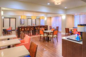 un restaurant avec des tables et des chaises ainsi qu'un bar dans l'établissement Hampton Inn Baton Rouge - Denham Springs, à Denham Springs