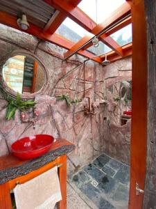 a bathroom with a stone wall with a red sink at ProyectoQva Glamping in Villa Ballester