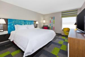 ein Hotelzimmer mit einem großen Bett und einem Fernseher in der Unterkunft Hampton Inn Marysville in Marysville