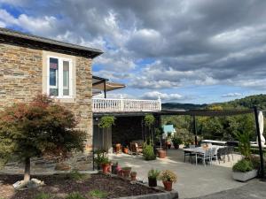 a patio with a deck and a table and chairs at Casa Acougo, Sarria in Sarria