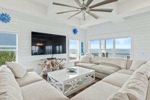 a living room with a couch and a tv at St Joe Beach House - Sailfish by Panhandle Getaways in Saint Joe Beach