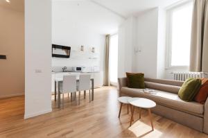 uma sala de estar com um sofá e uma mesa em Brera Apartments in San Babila em Milão