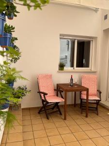 a room with a table and two chairs and a window at KALUKA Málaga center apartment - free parking in Málaga