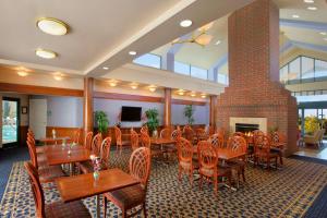 a restaurant with tables and chairs and a fireplace at Homewood Suites by Hilton Falls Church in Merrifield