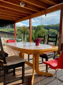 una mesa de madera y sillas en una terraza con mesa en 1Zi Ferienwohnung bis zu 3 Personen für Dienstreisende in Loßburg Schwarzwald en Loßburg