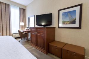 Habitación de hotel con cama y TV de pantalla plana. en Hampton Inn St. Louis Southwest, en Fenton