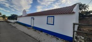 a white and blue building with a red roof at Monte da Venda de Baixo in Santa Margarida da Serra