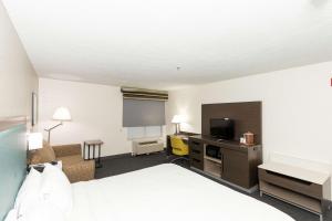 a hotel room with a bed and a desk with a television at Hampton Inn Kerrville in Kerrville