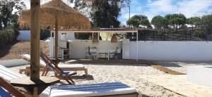 a patio with chairs and an umbrella and a table at Monte da Venda de Baixo in Santa Margarida da Serra