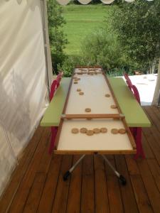 - une table de pique-nique sur une terrasse avec 2 chaises dans l'établissement GITE LES 1000 FLEURS, à Souteyros